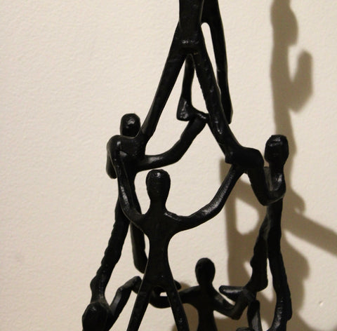 Close-up of connected figures and textured black finish on Tower of Humans sculpture