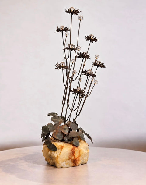 Side view of vintage metal floral tabletop sculpture on stone base