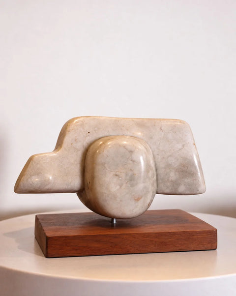 Cream marble abstract sculpture with stepped and oval forms on a rectangular wood base