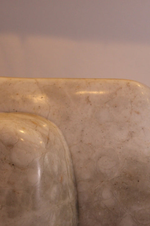 Close-up of the marble sculpture's flat stepped form and natural stone markings